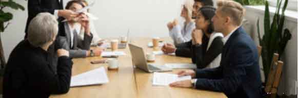 Une équipe de personnes discutant autour d'une table, représentant un conseil syndical.